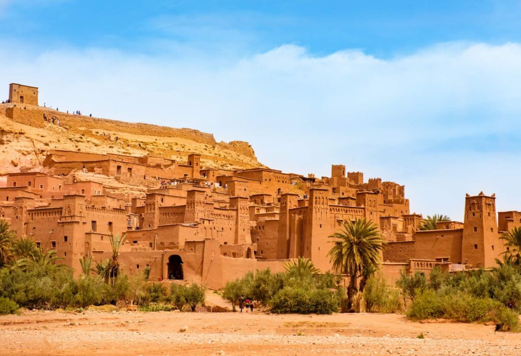 Vue spectaculaire d’un village marocain en terre rouge à flanc de montagne, parfait pour illustrer un voyage hors des sentiers battus